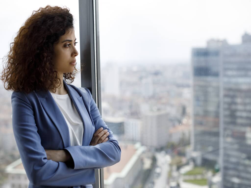 a worried businesswoman looking out of the window